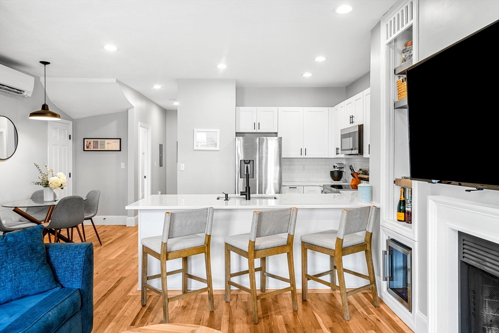 7 O Street, Unit 1 Boston, MA 02127 - Photo 3 of 15 a kitchen with stainless steel appliances a stove a sink a dining table and chairs