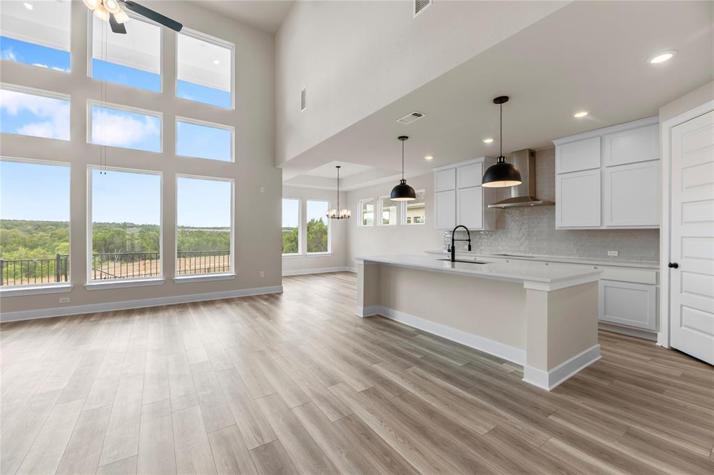 1545 Rodeo Ridge Drive Georgetown, TX 78628 - Photo 4 of 33 Kitchen featuring pendant lighting, white cabinetry, wall chimney exhaust hood, a center island with sink, and recessed lighting