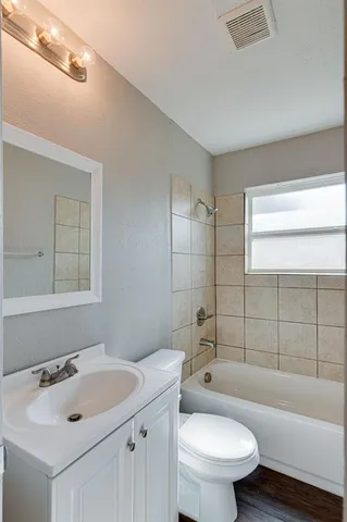 a bathroom with a sink toilet vanity and bathtub
