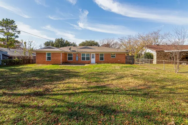 a view of a house with a big yard and large trees
