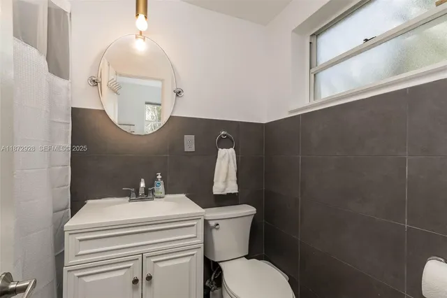 a bathroom with a sink mirror and toilet