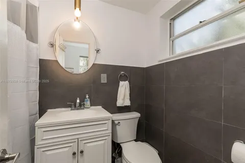 a bathroom with a sink mirror and toilet