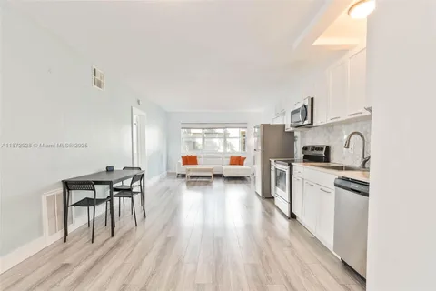 a kitchen with stainless steel appliances a stove a sink a refrigerator and wooden floor