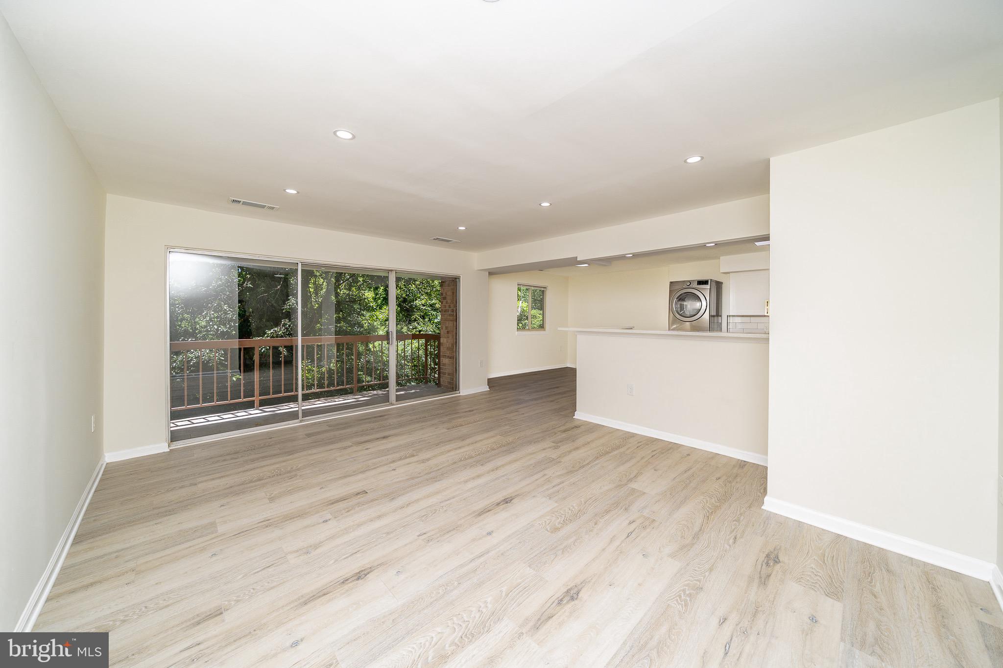 9910 Walker House Road, Unit 99104 Gaithersburg, MD 20886 - Photo 6 of 32 a view of a big room with wooden floor and windows