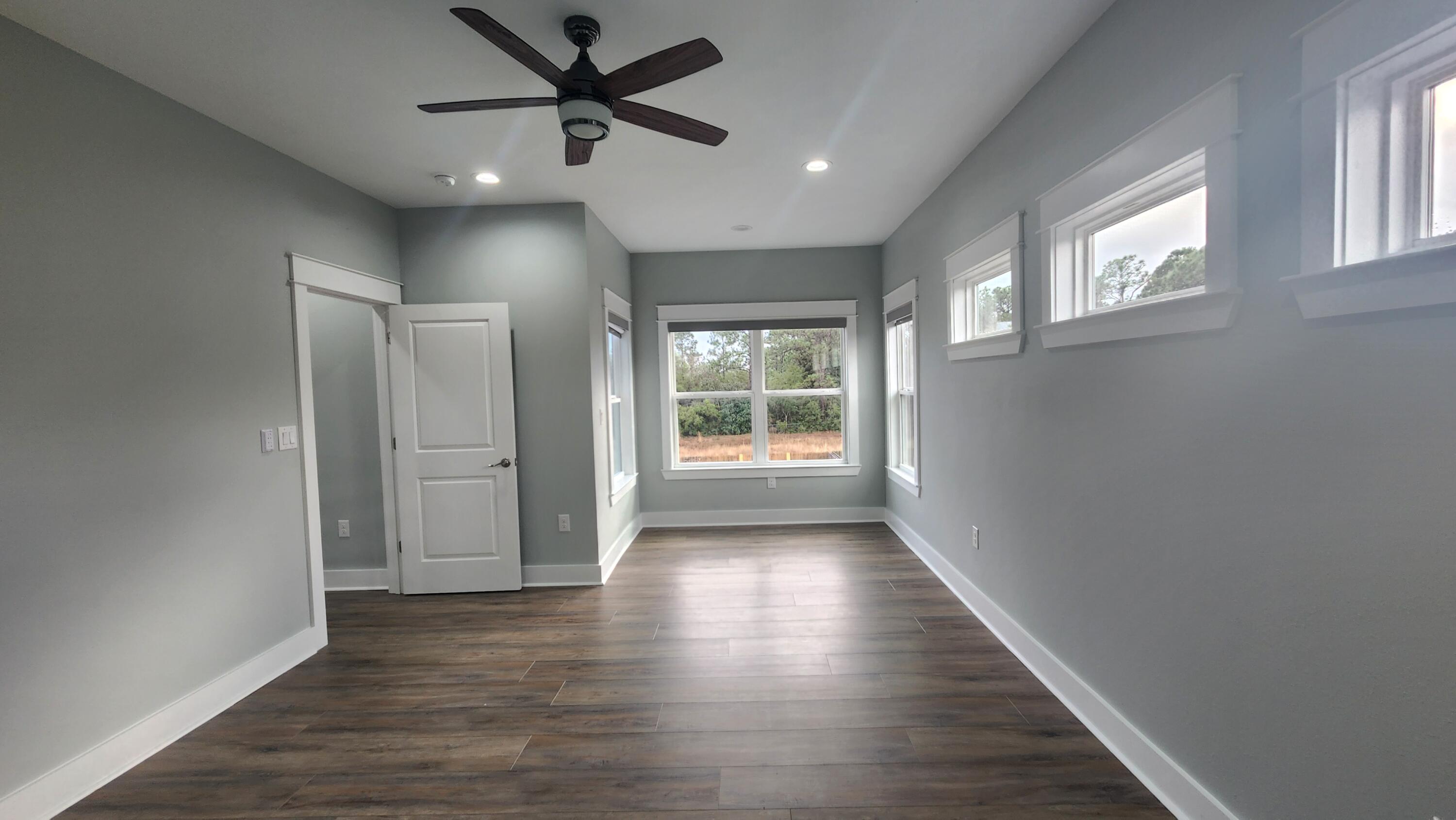 9149 Timber Lane Navarre, FL 32566 - Photo 19 of 44 a view of an empty room with wooden floor and a window