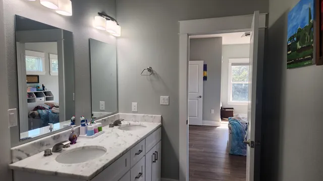 a bathroom with a granite countertop sink and a mirror