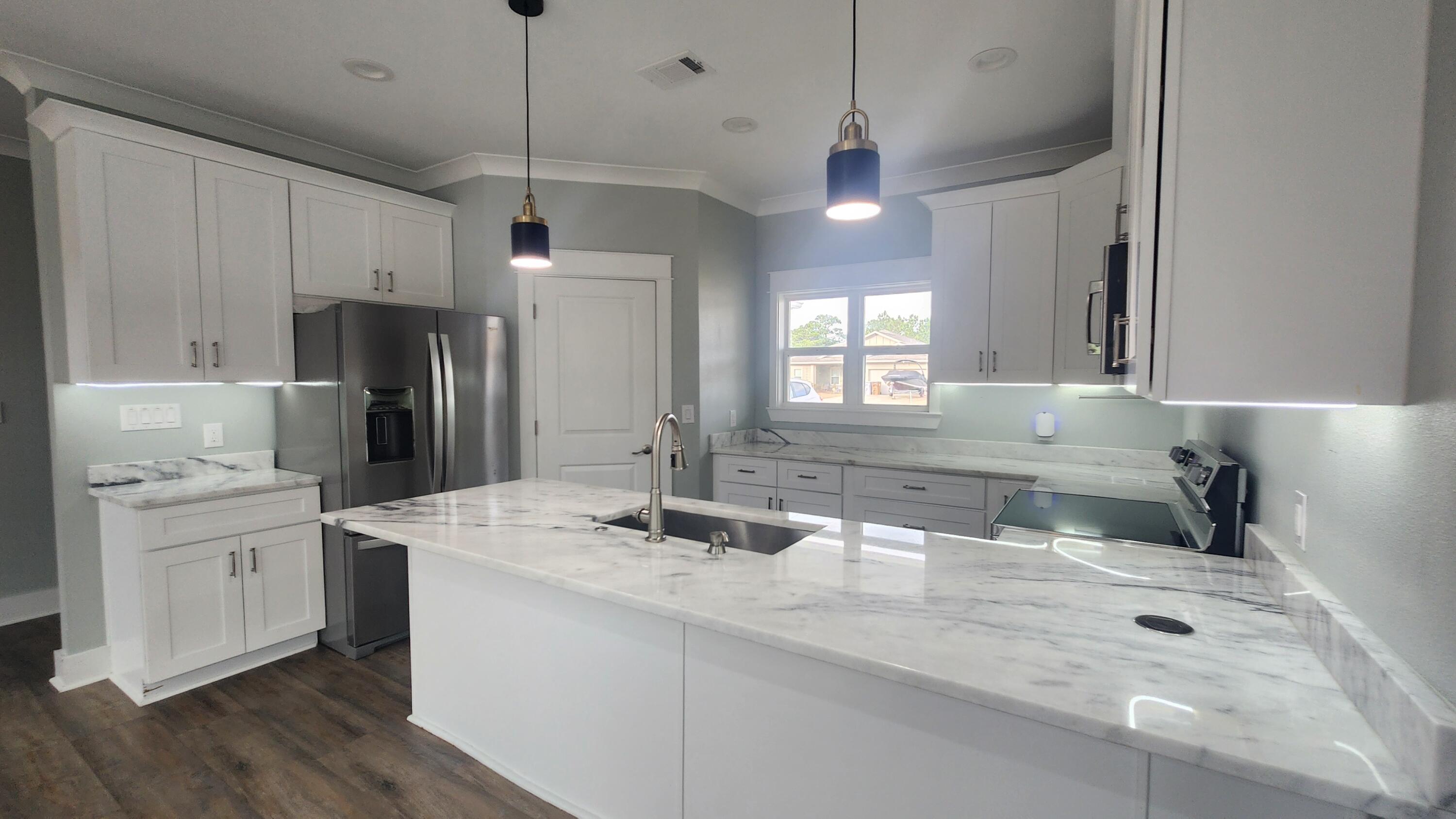 9149 Timber Lane Navarre, FL 32566 - Photo 3 of 44 a kitchen with a sink a center island cabinets and stainless steel appliances