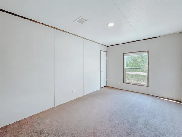 an empty room with windows and closet