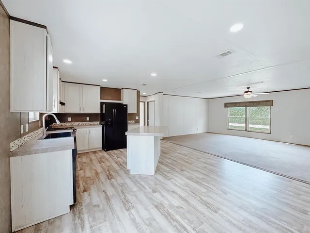 a kitchen with a refrigerator and a stove top oven