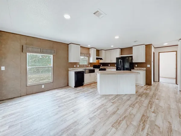 a large kitchen with a center island and stainless steel appliances