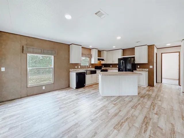 a large kitchen with a center island and stainless steel appliances