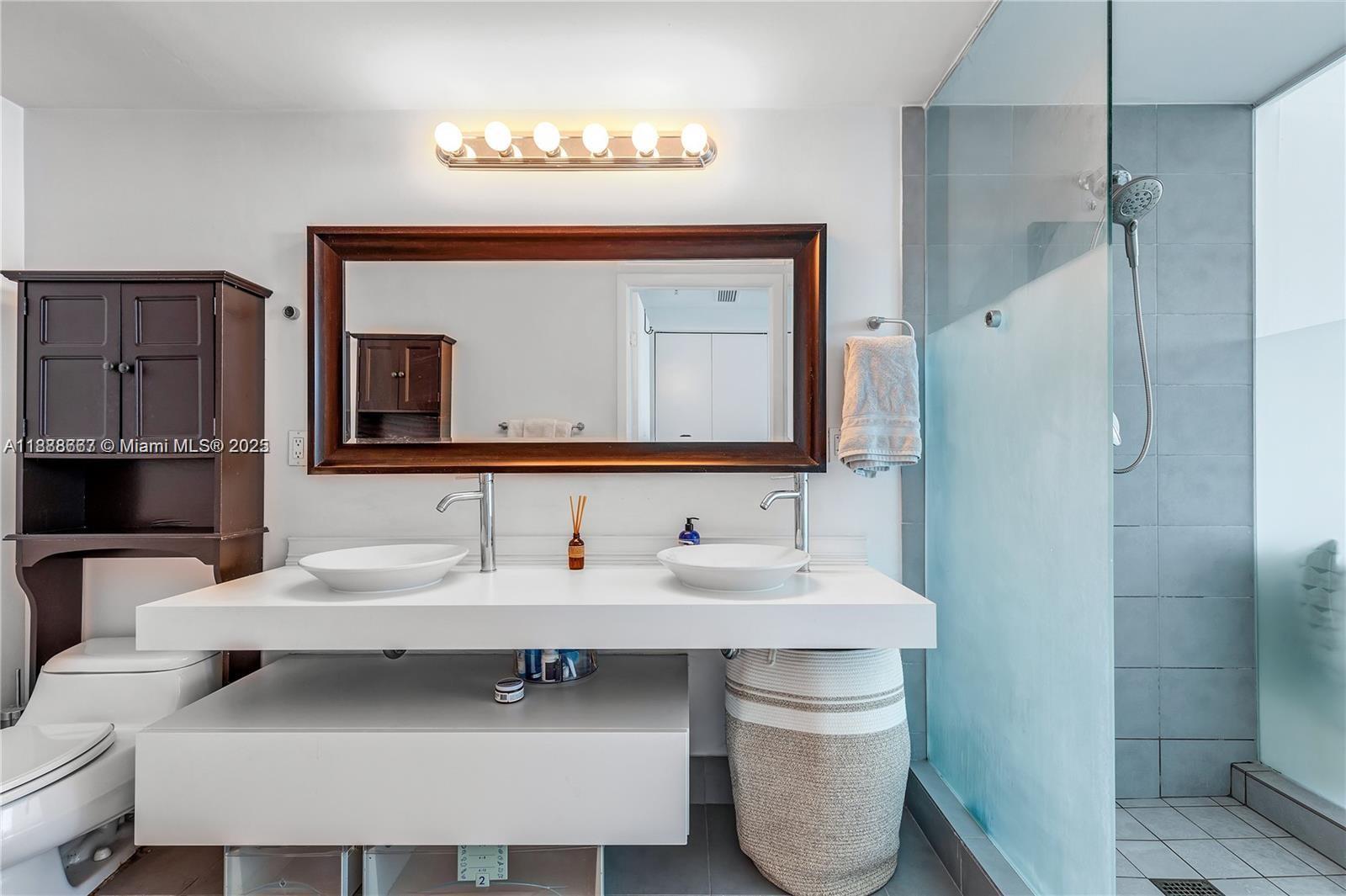 92 Southwest 3rd Street, Unit 3012 Miami, FL 33130 - Photo 14 of 18 a bathroom with a sink and a mirror