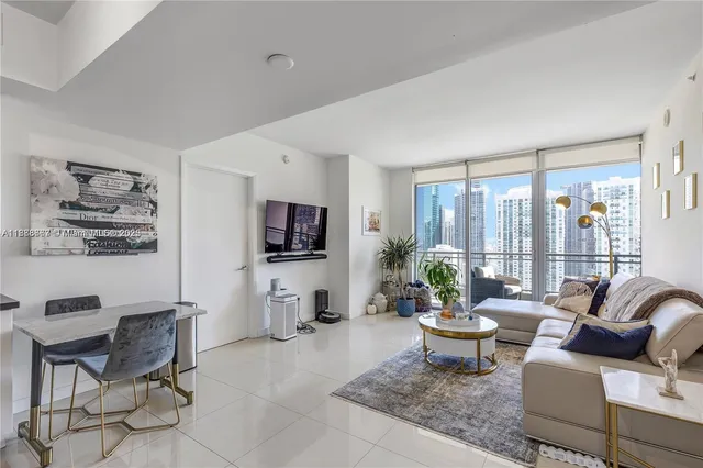 a living room with furniture a flat screen tv and a large window