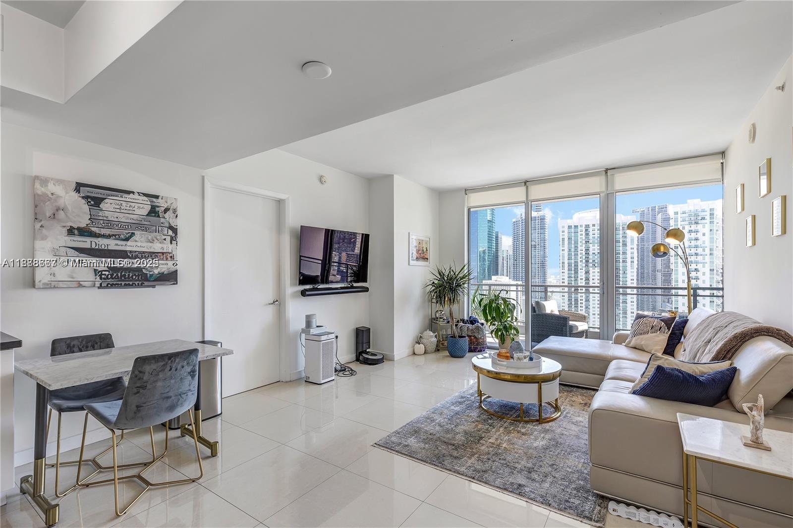 92 Southwest 3rd Street, Unit 3012 Miami, FL 33130 - Photo 8 of 18 a living room with furniture a flat screen tv and a large window