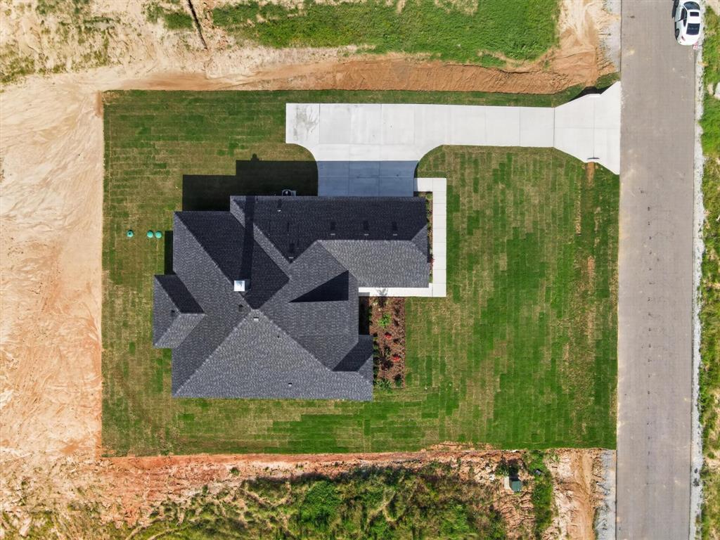 416 McAlpine Drive Springtown, TX 76082 - Photo 36 of 40 New construction home featuring a multi-pitched dark gray shingle roof, concrete driveway, and established lawn