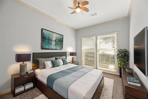 a bedroom with a large bed and a flat tv screen on dresser