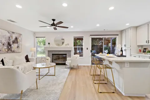 a kitchen with stainless steel appliances kitchen island wooden floors and white cabinets