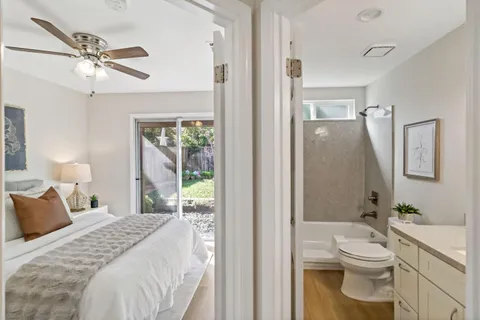 a bathroom with a granite countertop tub sink and mirror