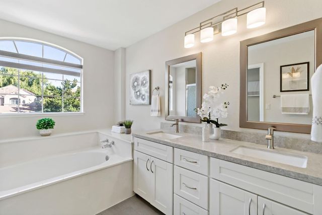 a bathroom with a bathtub a sink and a window