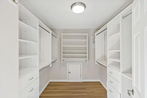 a view of walk in closet with empty racks