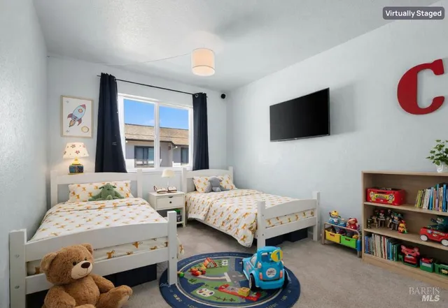 a bedroom with a bed a flat screen tv and a couch