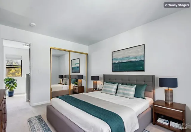 a bedroom with a bed a couch and a potted plant