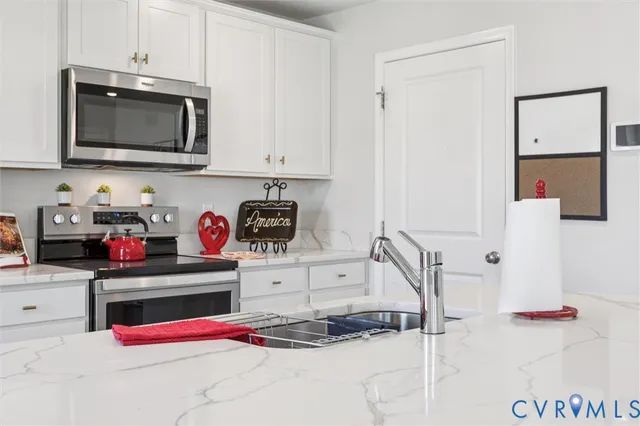 a kitchen with stainless steel appliances granite countertop a sink and a microwave