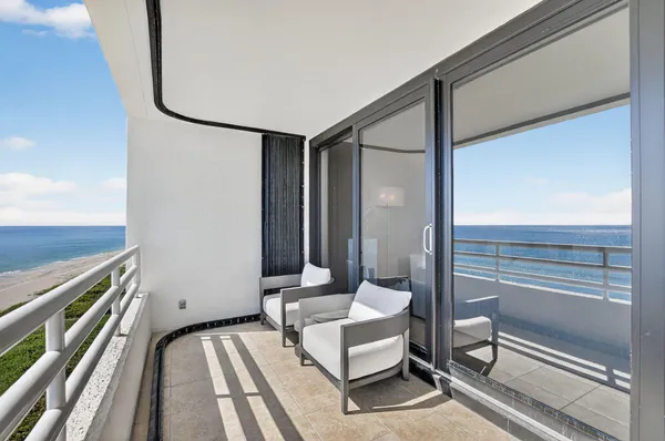 a living room with furniture a kitchen view and a large window