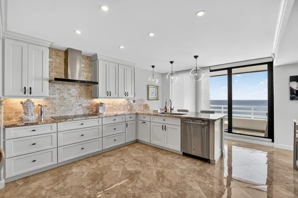 a kitchen with stainless steel appliances granite countertop a refrigerator and a sink