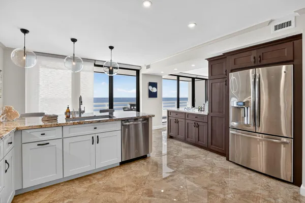 a kitchen with granite countertop a refrigerator and a stove top oven