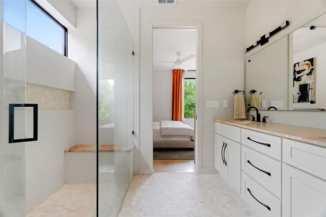 a en suite bathroom with a sink a window and a mirror