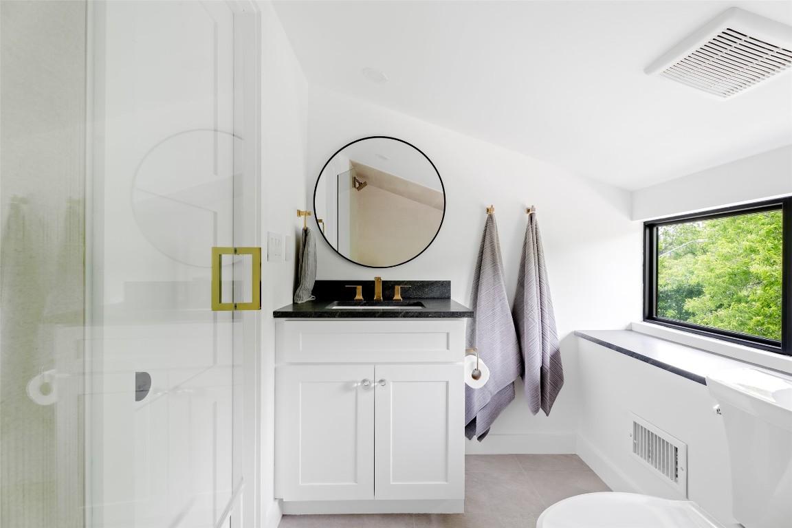 4911 Duval Street Austin, TX 78751 - Photo 28 of 40 a bathroom with a sink a toilet and a mirror
