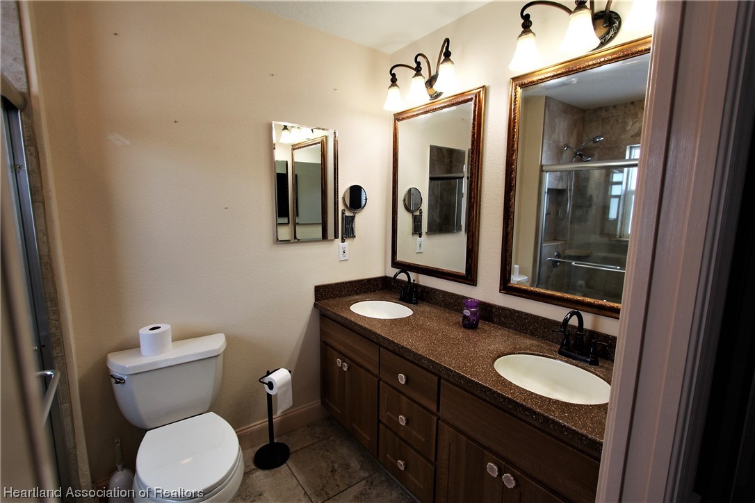 20 Quail Roost Road Lake Placid, FL 33852 - Photo 25 of 28 a bathroom with a granite countertop toilet sink and mirror