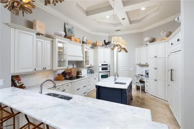 a large white kitchen with a refrigerator a stove a sink dishwasher and white cabinets with wooden floor