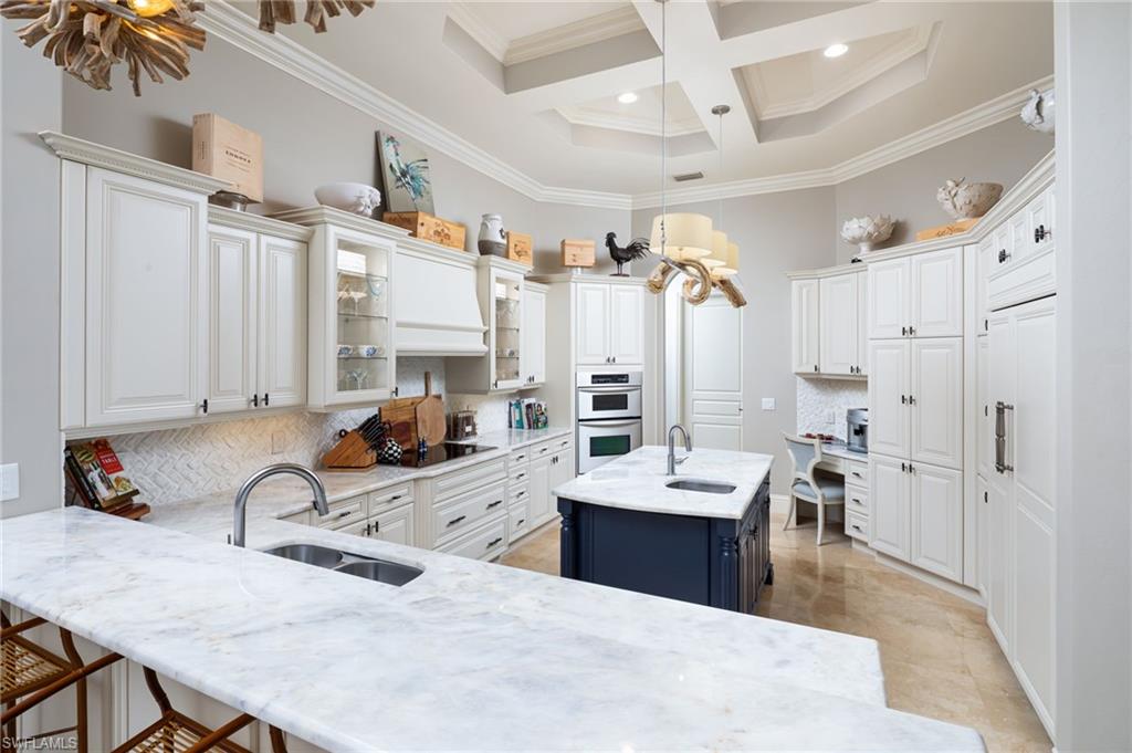 4610 Via Cappello Estero, FL 34134 - Photo 19 of 50 a large white kitchen with a refrigerator a stove a sink dishwasher and white cabinets with wooden floor