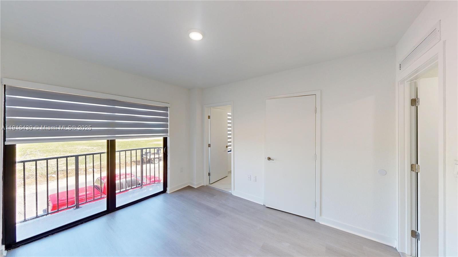 14546 Southwest 260th Street, Unit 14546 Homestead, FL 33032 - Photo 20 of 31 a view of an empty room with wooden floor and windows