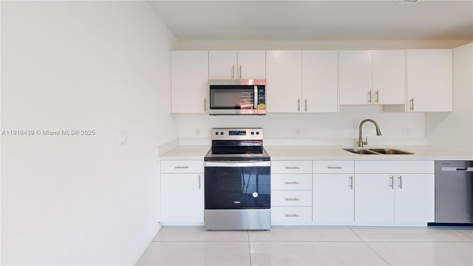 14546 Southwest 260th Street, Unit 14546 Homestead, FL 33032 - Photo 4 of 31 a kitchen with cabinets stainless steel appliances and a sink