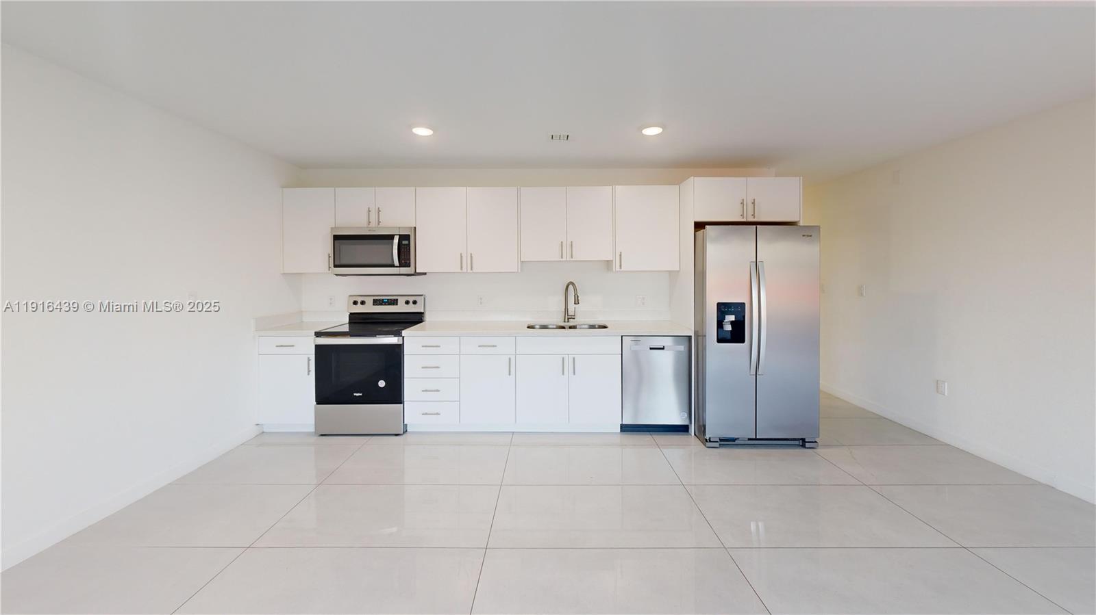 14546 Southwest 260th Street, Unit 14546 Homestead, FL 33032 - Photo 5 of 31 a kitchen with stainless steel appliances a refrigerator sink and cabinets
