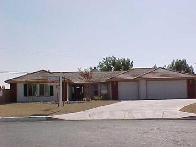 20451 Sundance Road Apple Valley, CA 92308 - Photo 1 of 1 a front view of a house with a garden