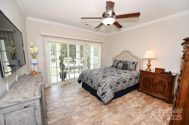 a bedroom with a bed dresser and a chandelier