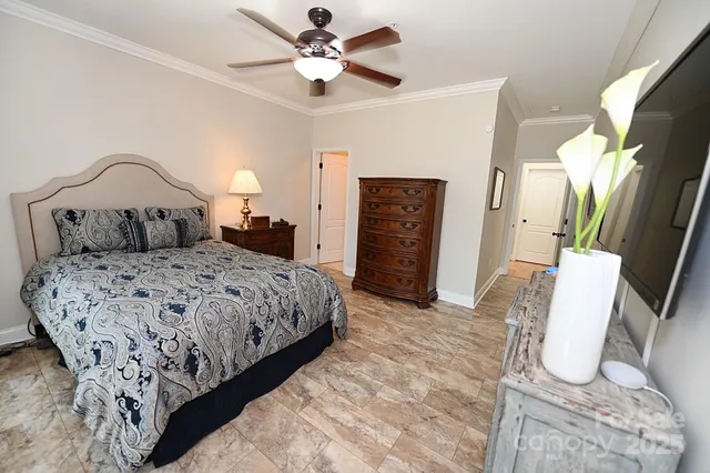 an empty room with a chandelier fan and windows