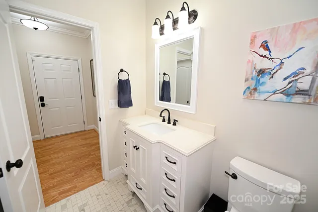 a bathroom with a granite countertop toilet sink and mirror