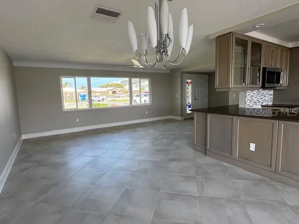 a view of a hallway with entryway windows and chandelier