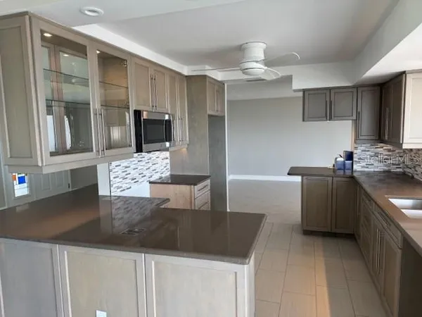 a kitchen with stainless steel appliances granite countertop a sink and a refrigerator