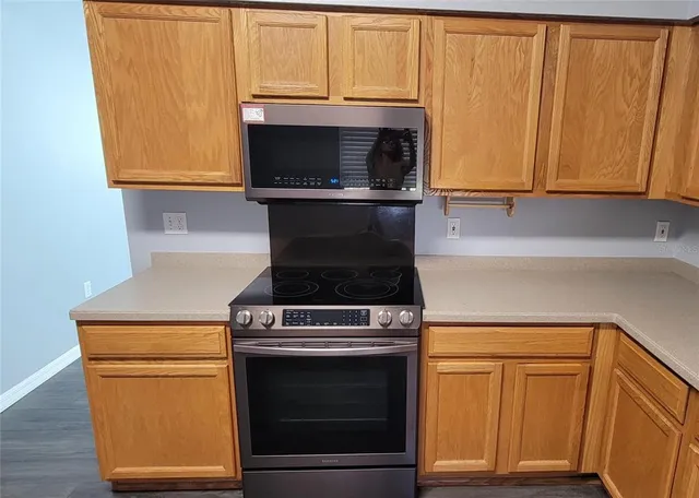 a kitchen with granite countertop cabinets stainless steel appliances and wooden cabinets