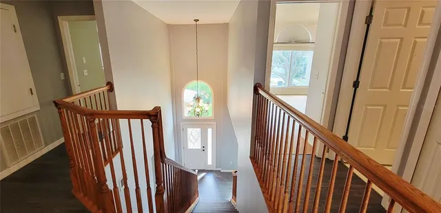 a view of a hallway with wooden floor and stairs