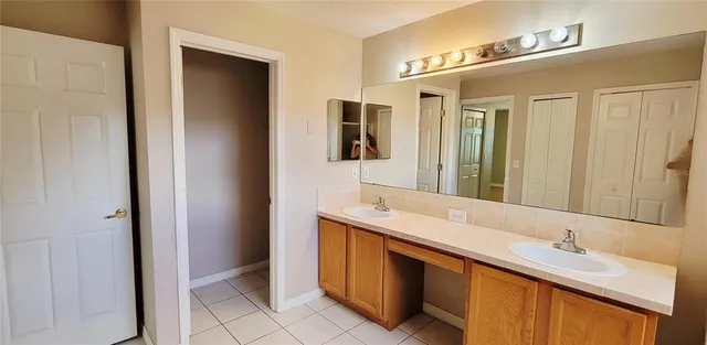 a bathroom with a double vanity sink and mirror