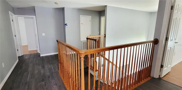 a view of a hallway with wooden floor and staircase