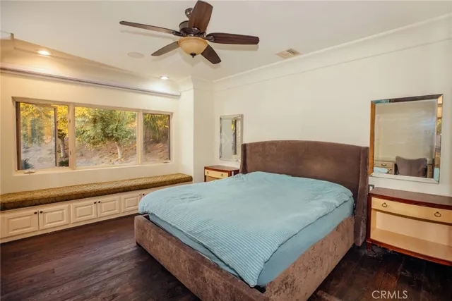 a bed sitting in a spacious bedroom next to a large window