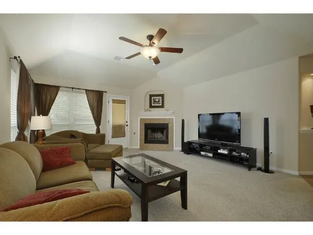 a living room with furniture a flat screen tv and a fireplace